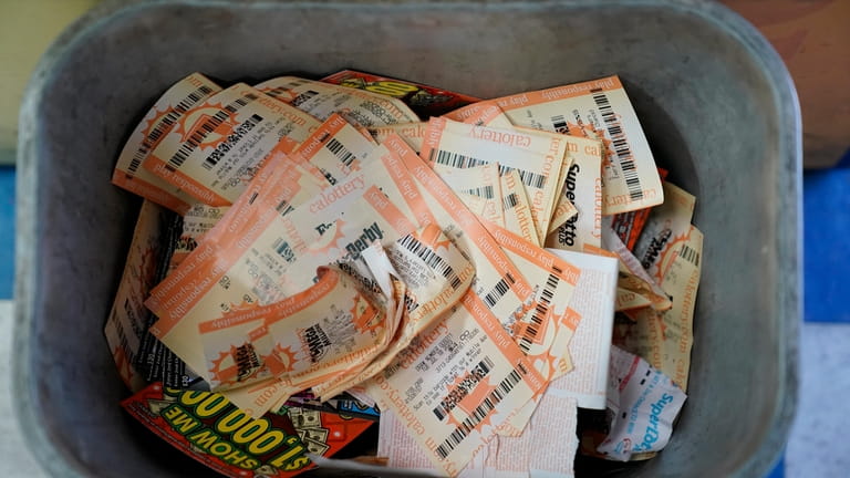 Powerball ticket receipts are seen in the garbage, Wednesday, July...