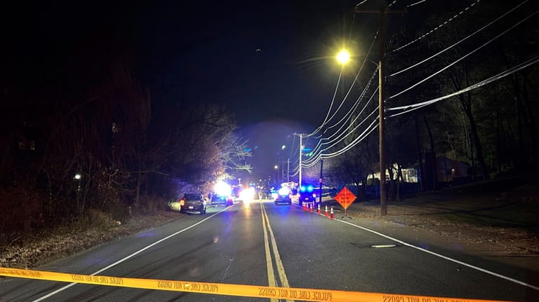 Police tape blocks a roadway in Waltham, Mass., after a...