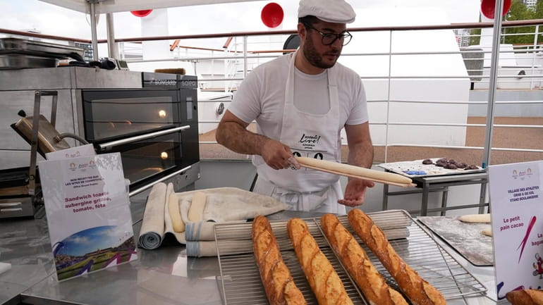 French baker Tony Dore prepares baguettes, like those that will...
