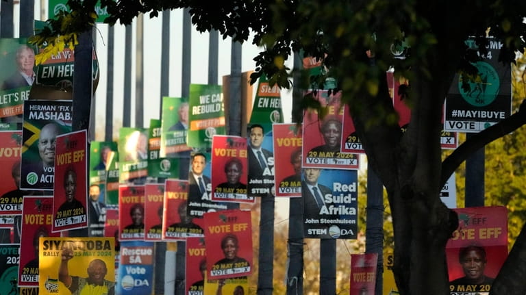 An array of election posters from various political parties are...