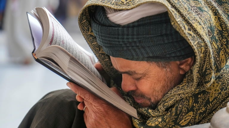 A Muslim reads the Islamic holy book "Quran", during the...