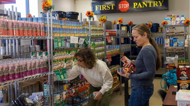 Volunteers Jennifer Hildreth of Huntington and Lisa Muuhbauer of Melville stock shelves at the...