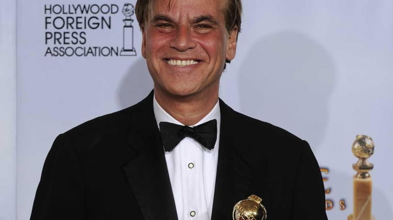 Aaron Sorkin holds the award he was given for Best...