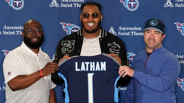 Tennessee Titans first round draft pick JC Latham, center, poses...