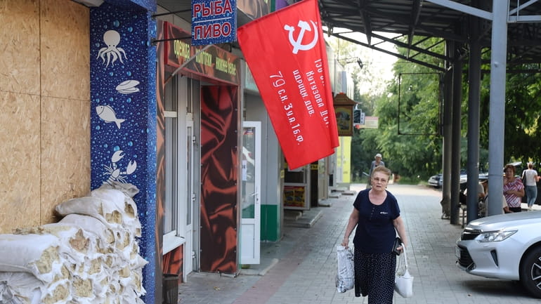 A woman walks past a shop decorated with a replica...