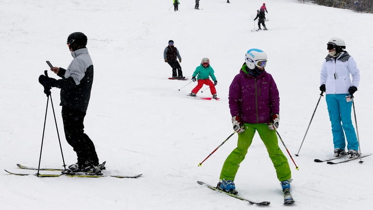  Skiers and riders make their way down the mountain at...