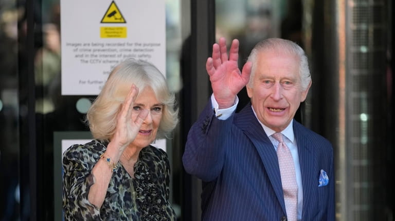 Britain's King Charles III and Queen Camilla wave as they...