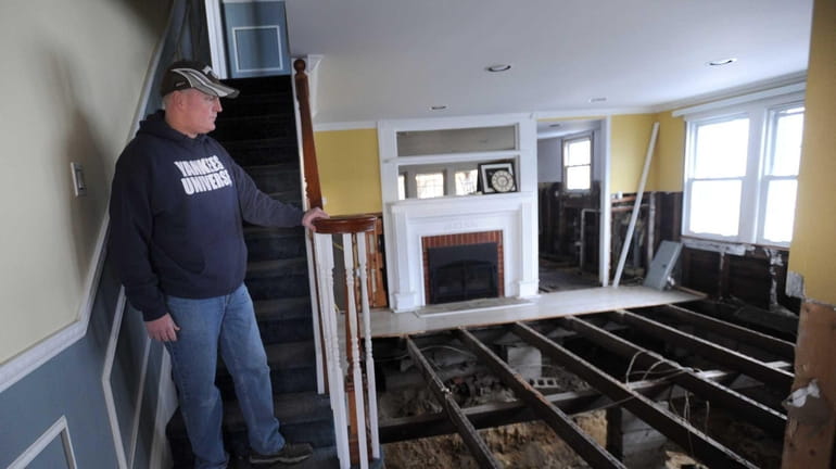 Glenn Devenish surveys the damage in his Massapequa home. Superstorm...