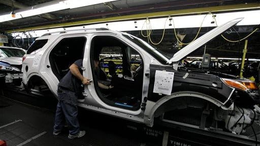 Plant employees assemble a 2011 Ford Explorer on the assembly...