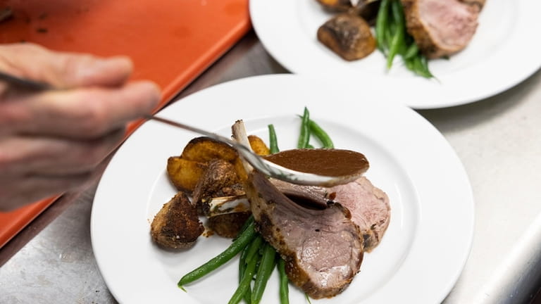 A rack of lamb, haricot verts, potatoes and gravy is...