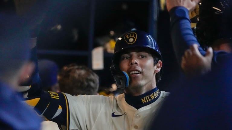 Milwaukee Brewers' Christian Yelich is congratulated after hitting a home...
