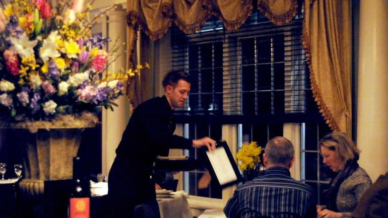 A server brings menus to diners at Blackwells Restaurant in...