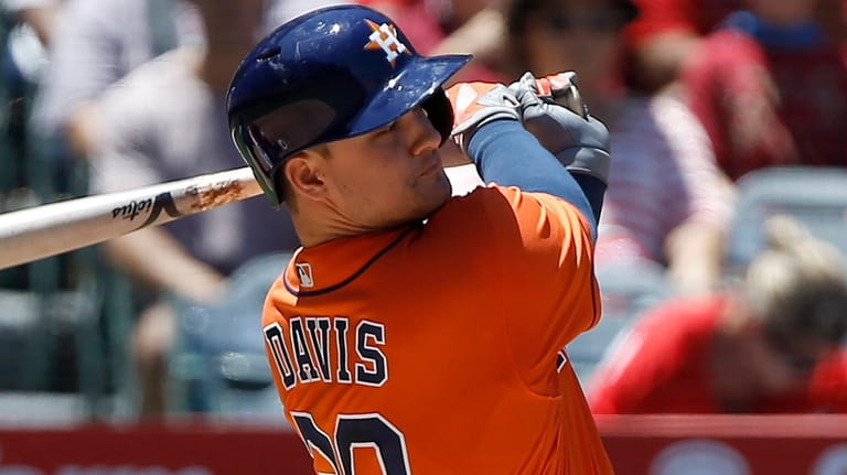 Houston Astros' J.D. Davis hits a run scoring single to...