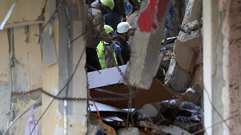Civil defense and rescue workers remove rubbles from a building...