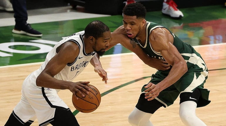 Kevin Durant of the Brooklyn Nets is defended by Giannis Antetokounmpo...