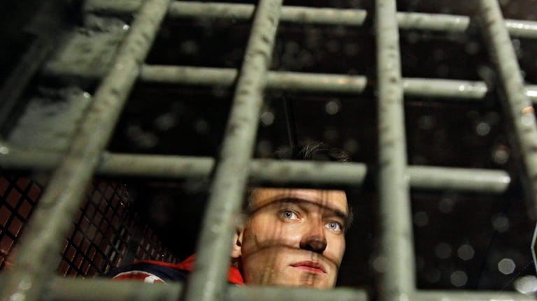 Alexei Navalny is seen behind the bars in the police...