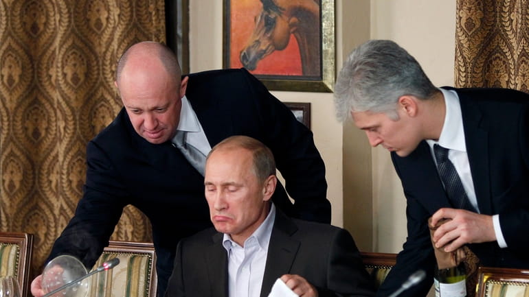 Yevgeny Prigozhin, left, serves food to then-Prime Minister Vladimir Putin,...