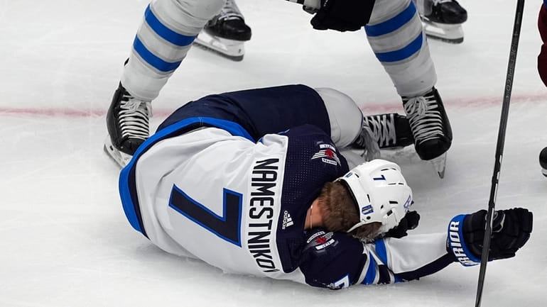 Winnipeg Jets center Vladislav Namestnikov (7) falls to the ice...