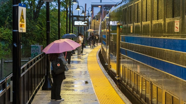 Rain-soaked commuters at the Port Jefferson Long Island Rail Road...
