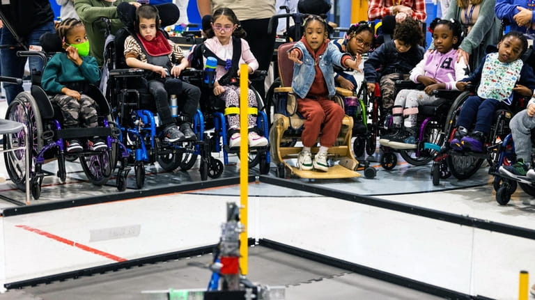 Students from The Henry Viscardi School watch a robot built by Mineola...