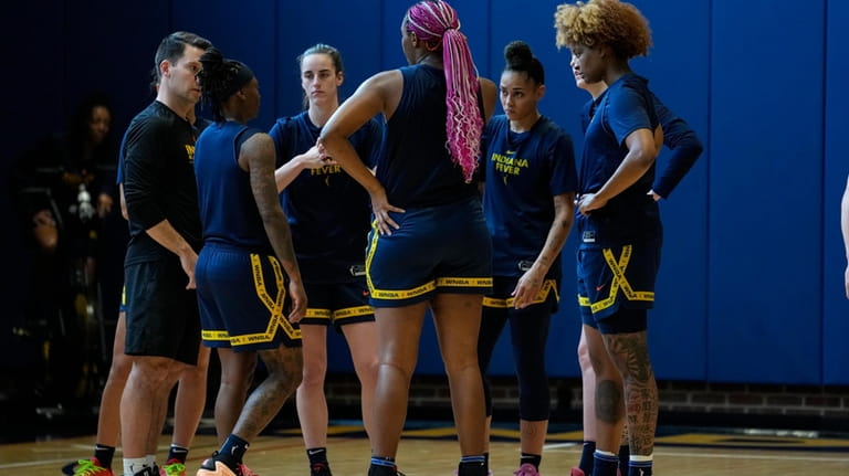Indiana Fever guard Caitlin Clark, third from left, huddles with...