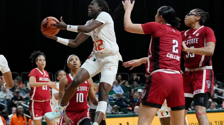 Miami guard Ja'Leah Williams (12) goes to the basket past...