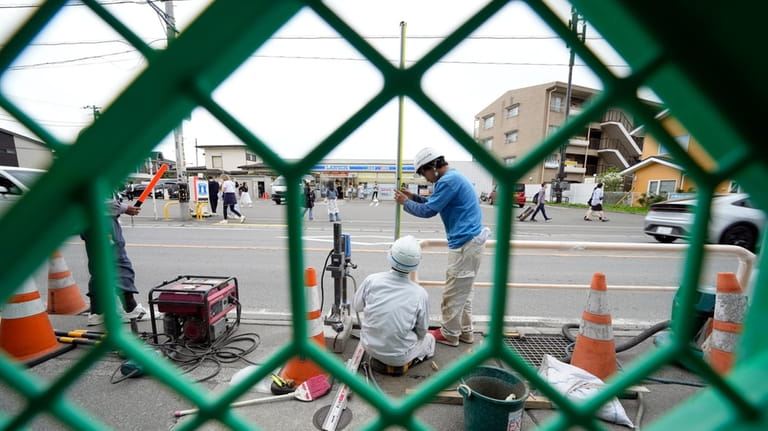 Workers set up a barricade near the Lawson convenience store,...