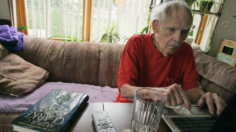 Science fiction writer Frederik Pohl works on his laptop at...