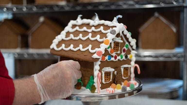 "Gingerbread Fred" Terry decorates a gingerbread house at Gingerbread University’s...