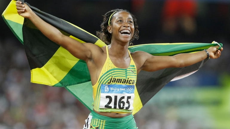 Shelly-Ann Fraser celebrates with the Jamaican flag after winning the...
