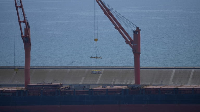 A crane loads food aid for Gaza onto the container...