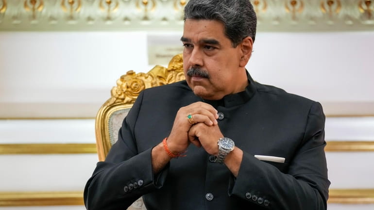 Venezuelan President Nicolás Maduro listens during their meeting at Miraflores...