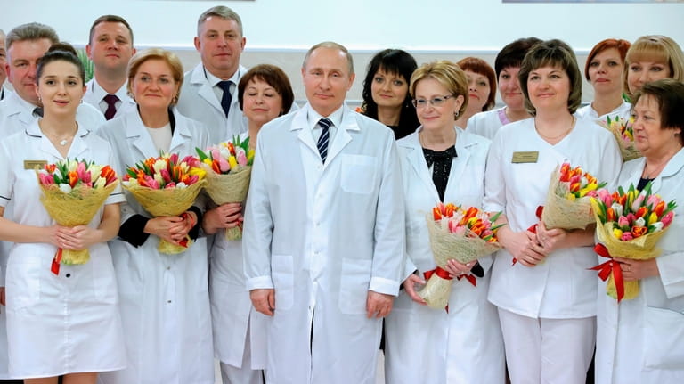 Russian President Vladimir Putin, center, and Health Minister Veronika Skvortsova,...