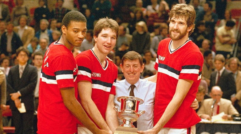 St. John's basketball coach Lou Carnesecca, center, flanked, by players...