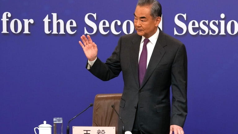 Chinese Foreign Minister Wang Yi waves as he arrives for...