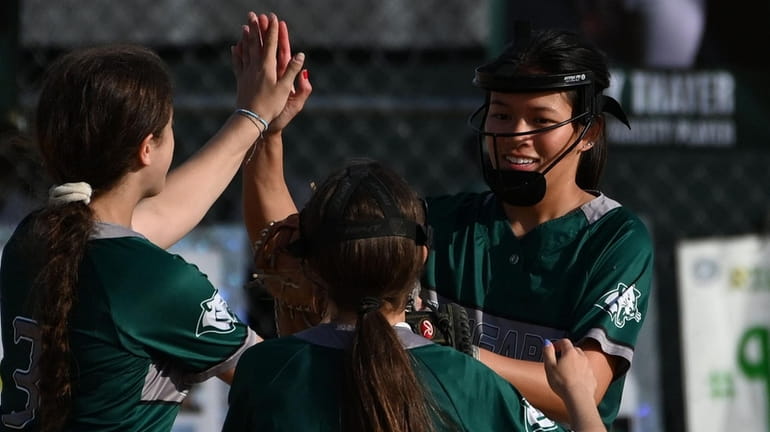 Lia Fong of Bellmore JFK, right, gets congratulated by teammates...