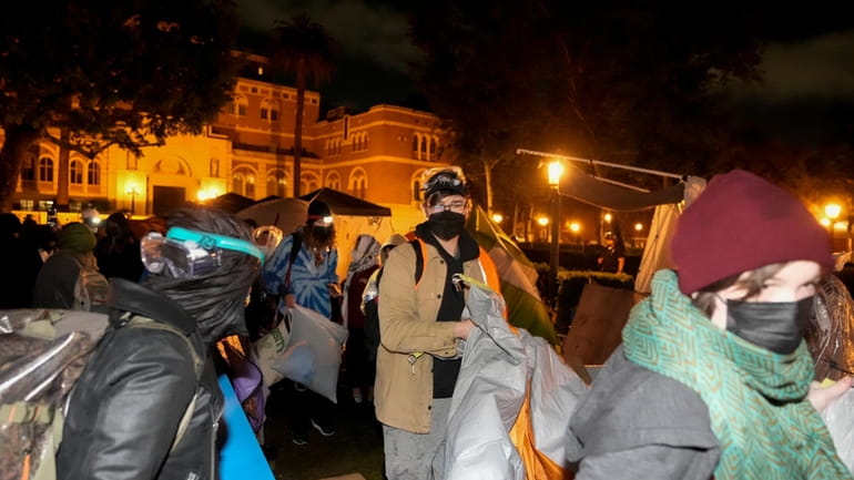 Pro-Palestinian demonstrators remove belongings from an encampment after police arrived...