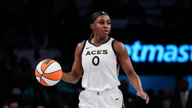 Las Vegas Aces' Jackie Young (0) brings the ball down...