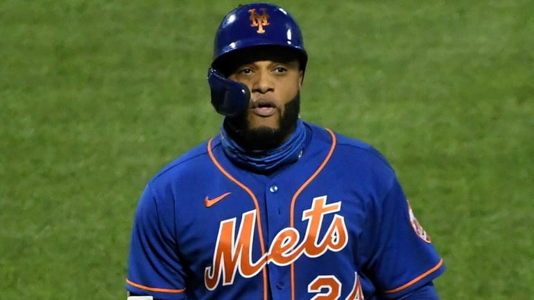 Mets designated hitter Robinson Cano returns to the dugout after...