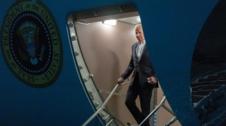 President Joe Biden walks down the ramp of Air Force...