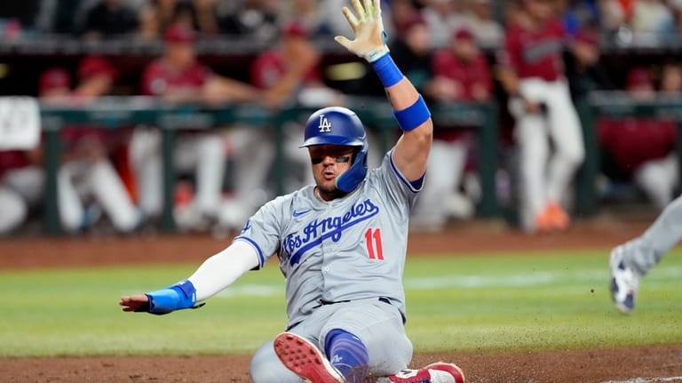Los Angeles Dodgers' Miguel Rojas scores on a base hit...