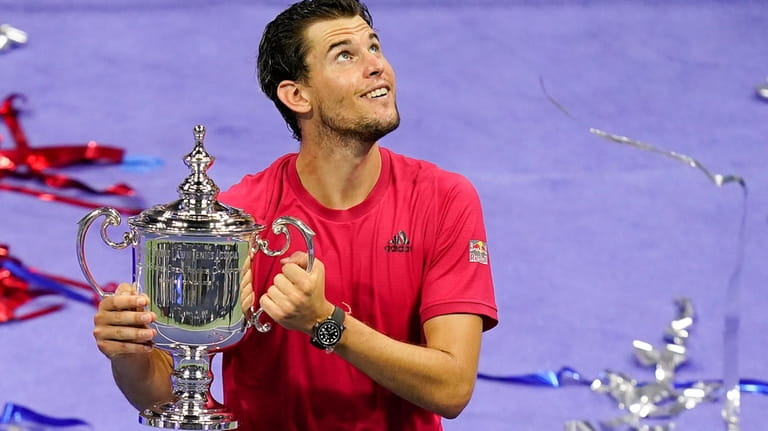 Dominic Thiem, of Austria, holds up the championship trophy after...