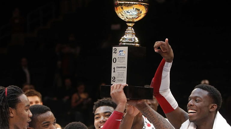Alabama's Trevor Lacey holds up the championship trophy with teammate...