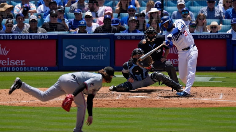 Los Angeles Dodgers' Teoscar Hernández, right, hits a two-run home...