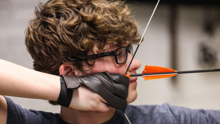 Noah Lyons, 13, of Medford, shoots an arrow during youth...
