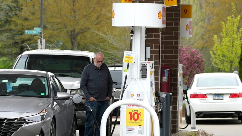 A customer fills up his vehicle's gas tank at a...