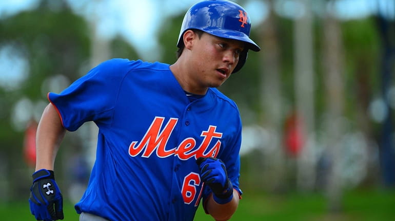 Mets' Wilmer Flores runs towards home plate after scoring on...