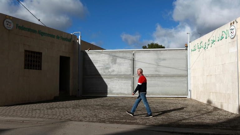 A man walks past the Algerian soccer federation, Thursday, Dec....