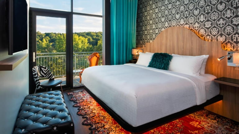 A king bed with a balcony view beckons guests at the...