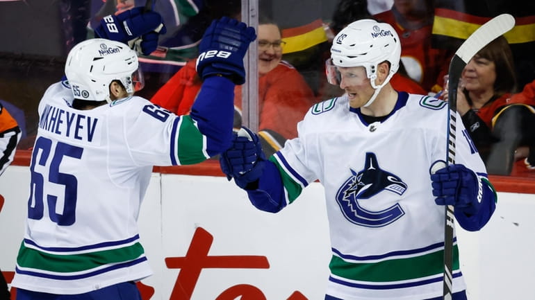 Vancouver Canucks forward Sam Lafferty, right, celebrates his goal with...